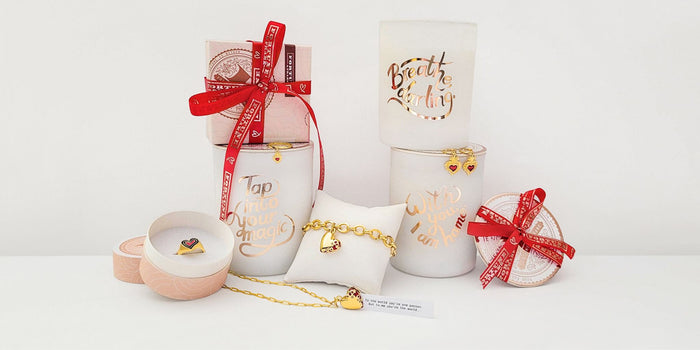 The Secret Fortune Candles, Gift boxes, Deco Heart Ring, Jeweled Heart Necklace, Jeweled Heart Bracelet, Sacred Heart Earrings, and Sacred Heart Ring displayed together.